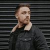A bearded man in a denim jacket