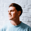 A man in a light blue T-shirt looking to the side