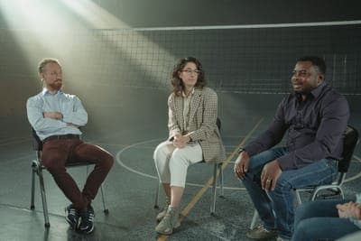 Three people listening in a circle of chairs