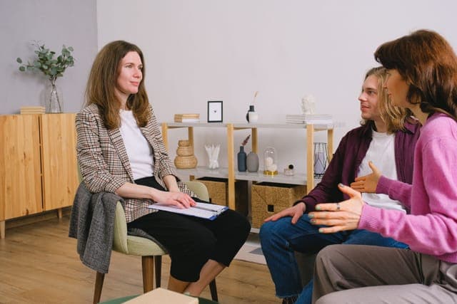 A group of women talking in a circle in a bright room
