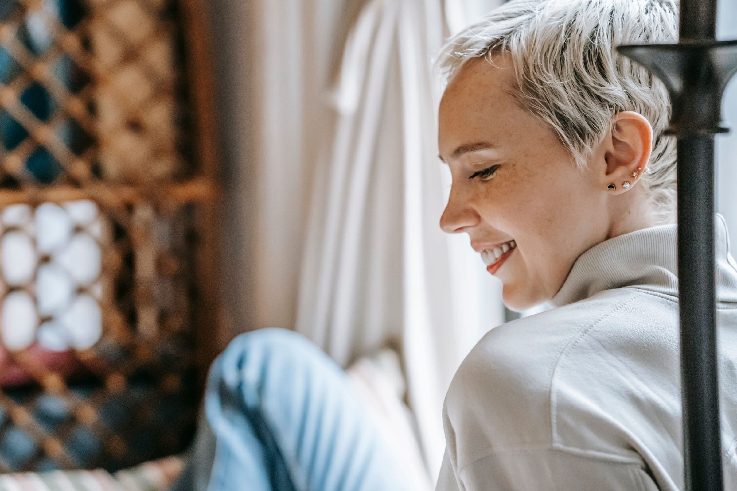 A woman with short grey hair smiling and looking down